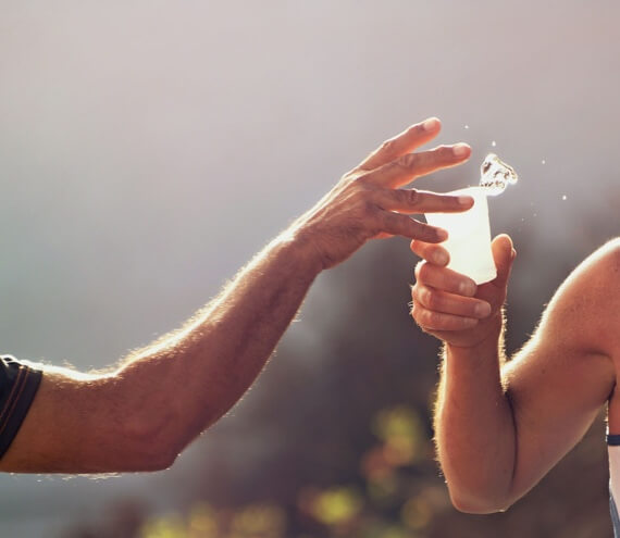 giving a cup of water to a runner